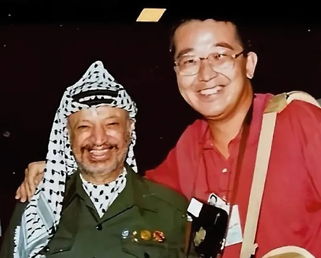戰地記者唐師曾與巴勒斯坦領導人阿拉法特合影。